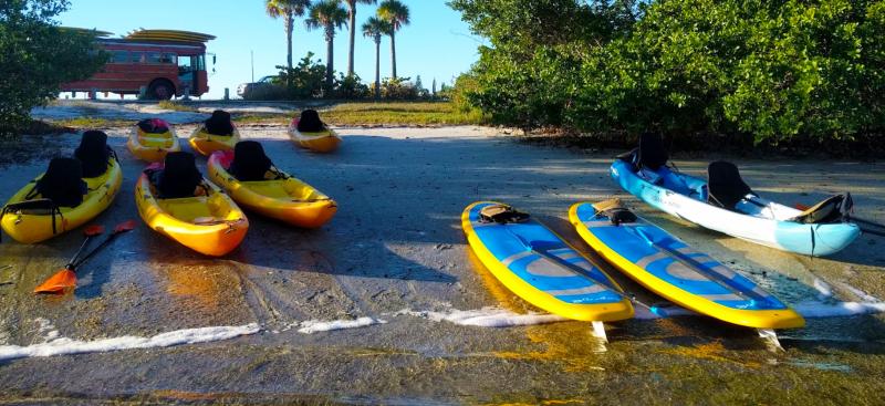 kayaks and paddle boards on river shore